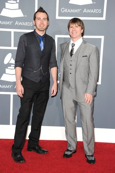 Two men in suits and ties standing next to each other.