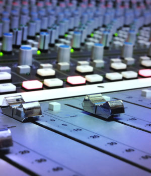 A close up of an audio mixing board