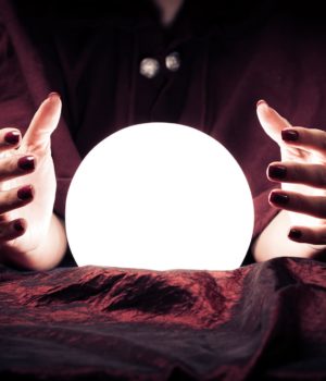A person with their hands on the table and a crystal ball