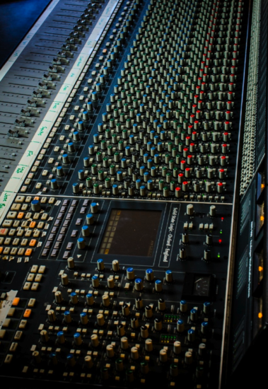 A large sound board with many different knobs.